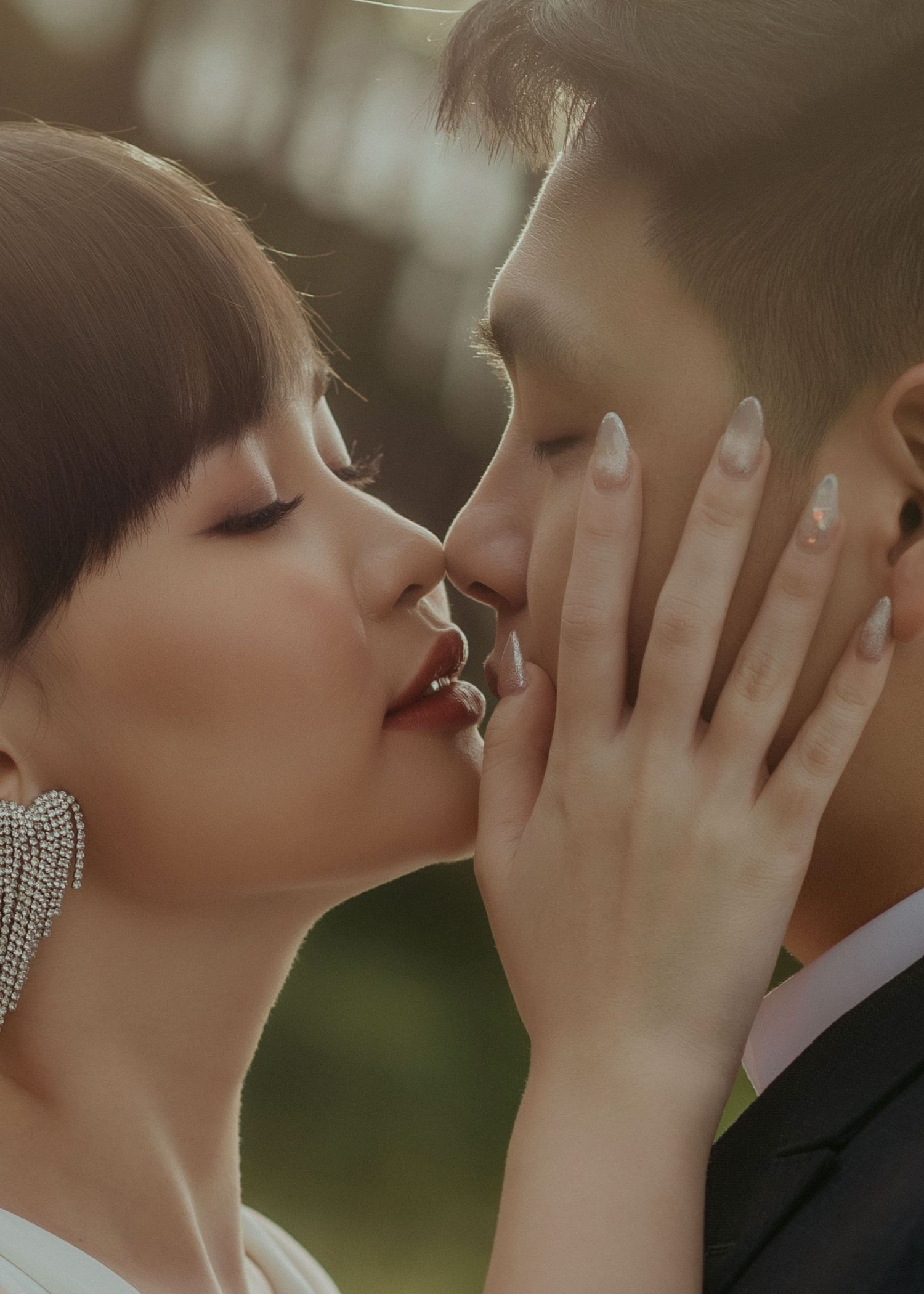 Romantic couple shares an intimate tender moment with light sparkles and soft blurry bokeh background in view.