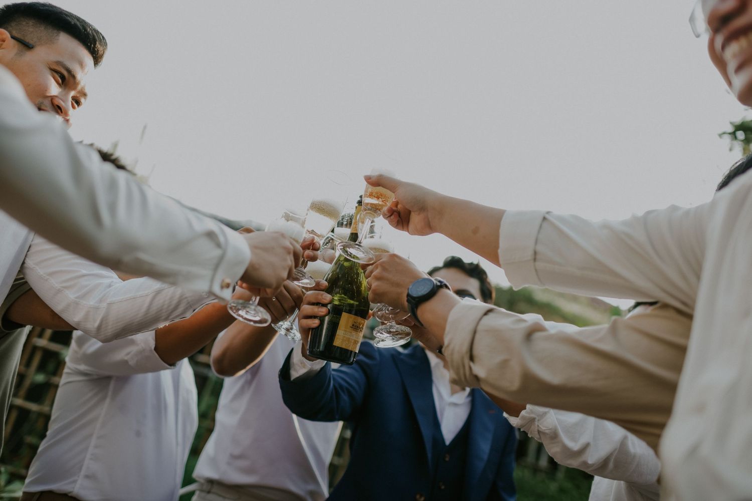 A group toasts with glasses of champagne during a celebratory outdoor gathering.