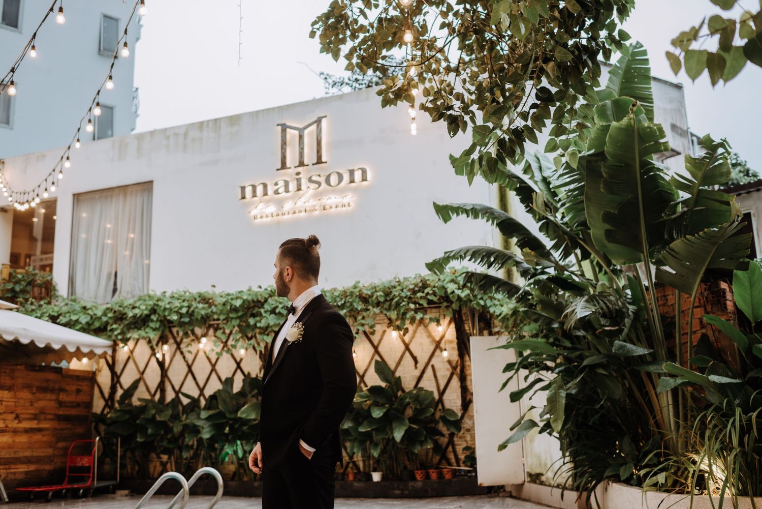 Wedding venue exterior with modern signage and greenery decorations.