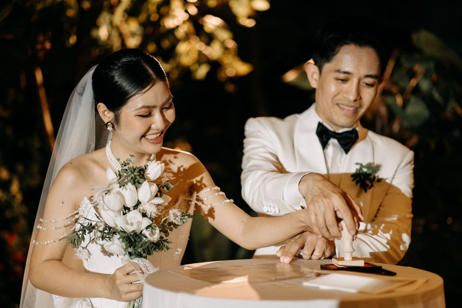 A wedding couple shares a joyful moment with a small brown dog during their ceremony.