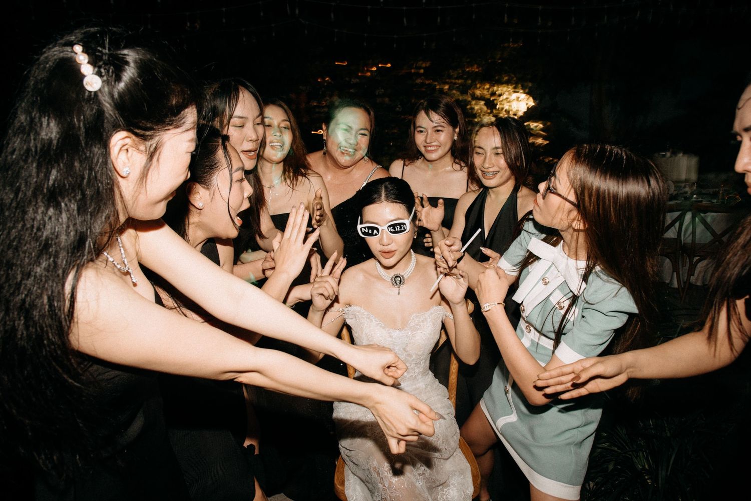 Group celebrates on dance floor during nighttime celebration.