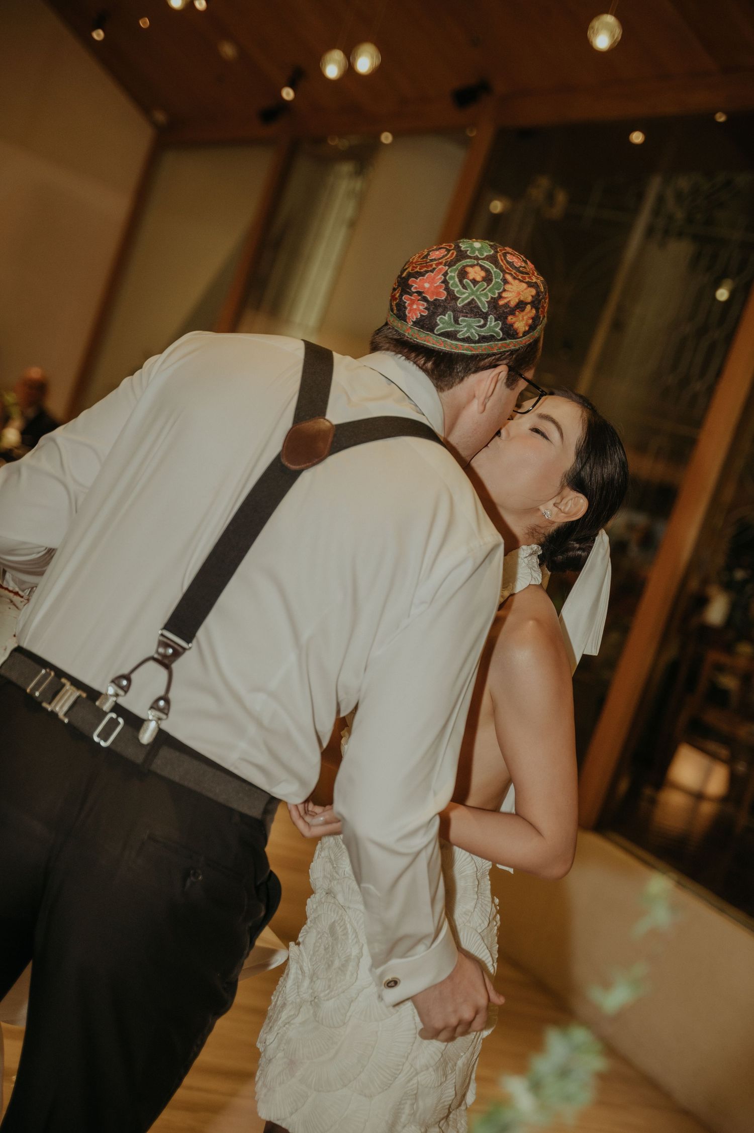 Romantic dip kiss during wedding reception dance.