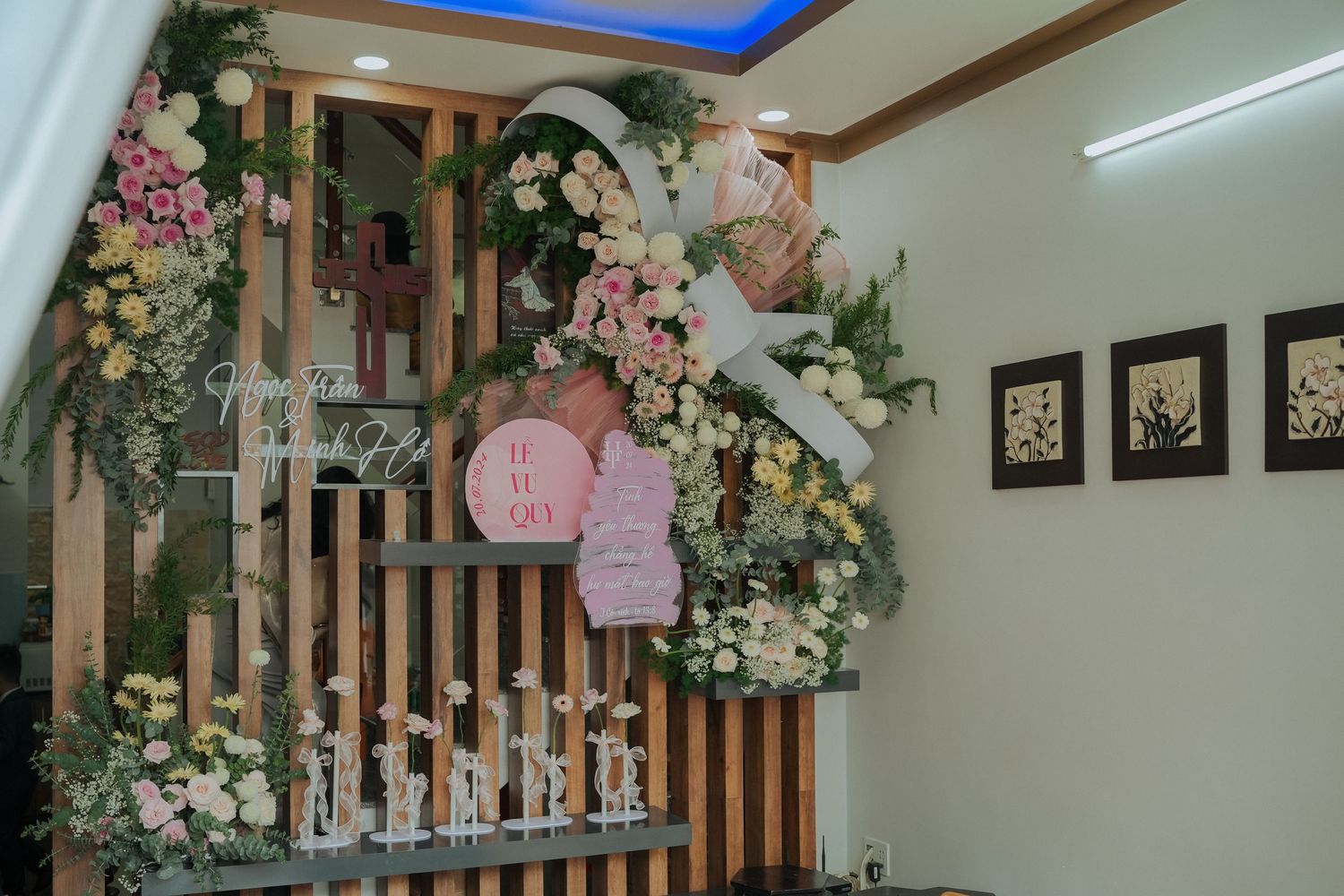 Elegant wooden partition wall decorated with pink lanterns and floral arrangements.
