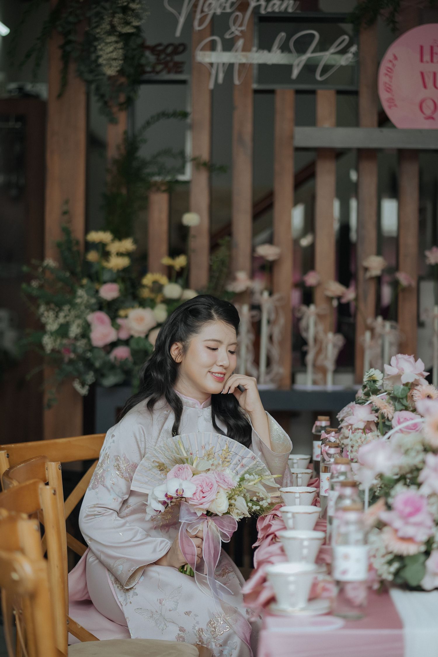Traditional tea ceremony setting with pink floral arrangements and wooden decor.