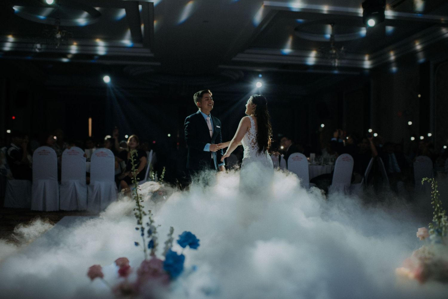 A dramatic wedding dance scene with fog effects and twinkling lights in an elegant reception venue.