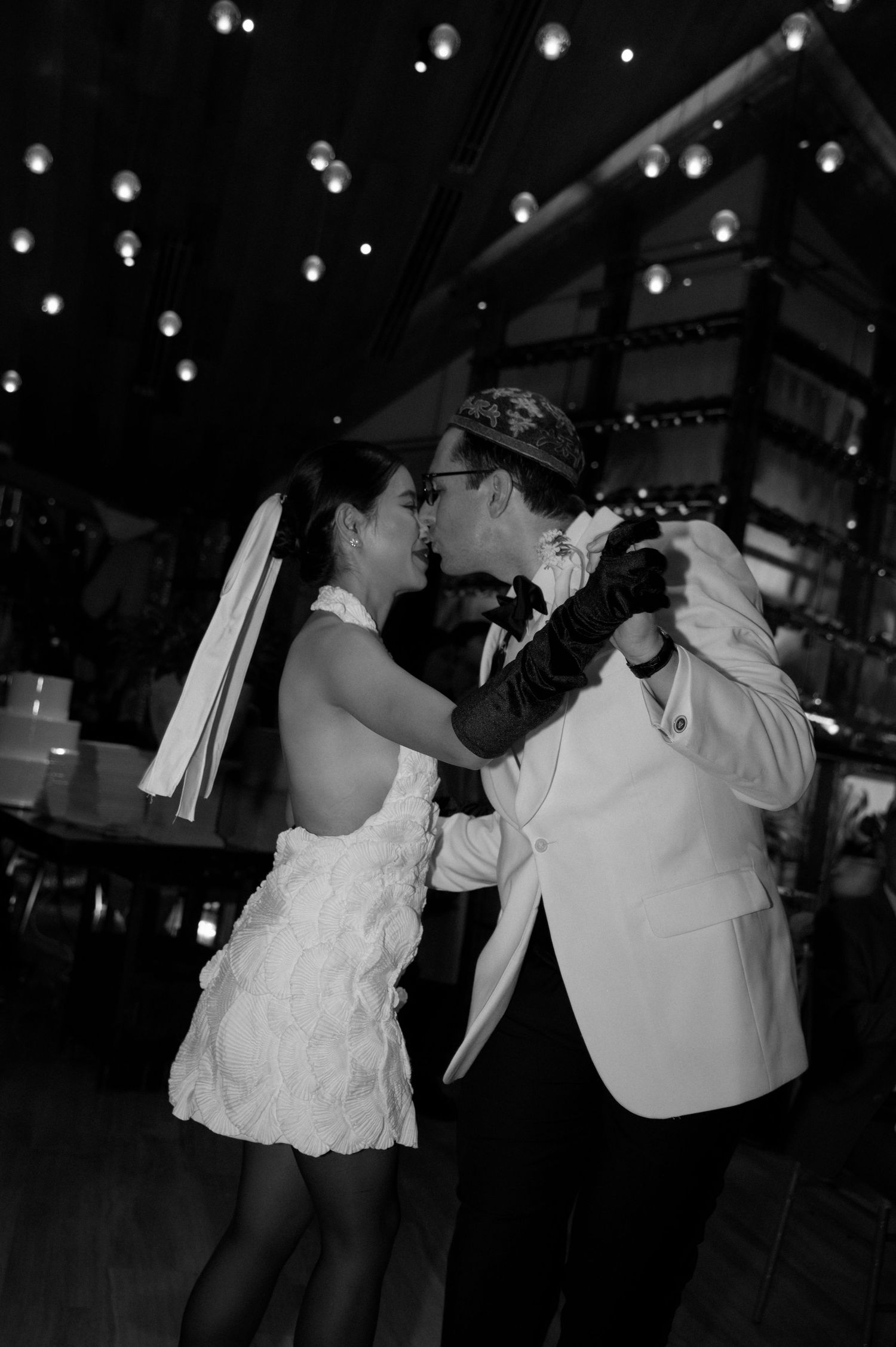 A couple shares a romantic dance under twinkling lights at their wedding reception.