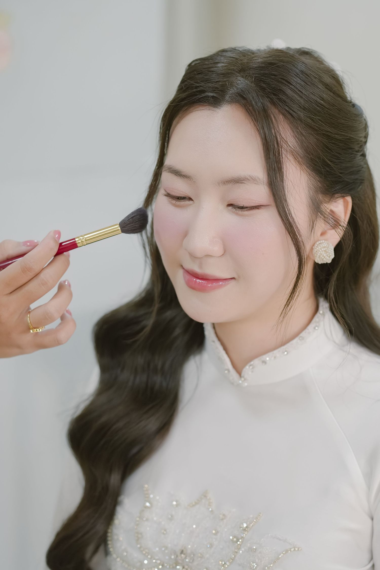 A closeup of wedding preparation showing makeup application with a brush.