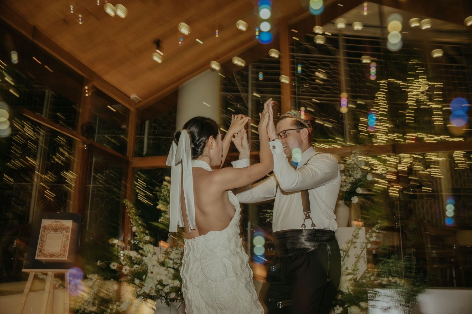 Couple dancing together under sparkling lights at their wedding reception.
