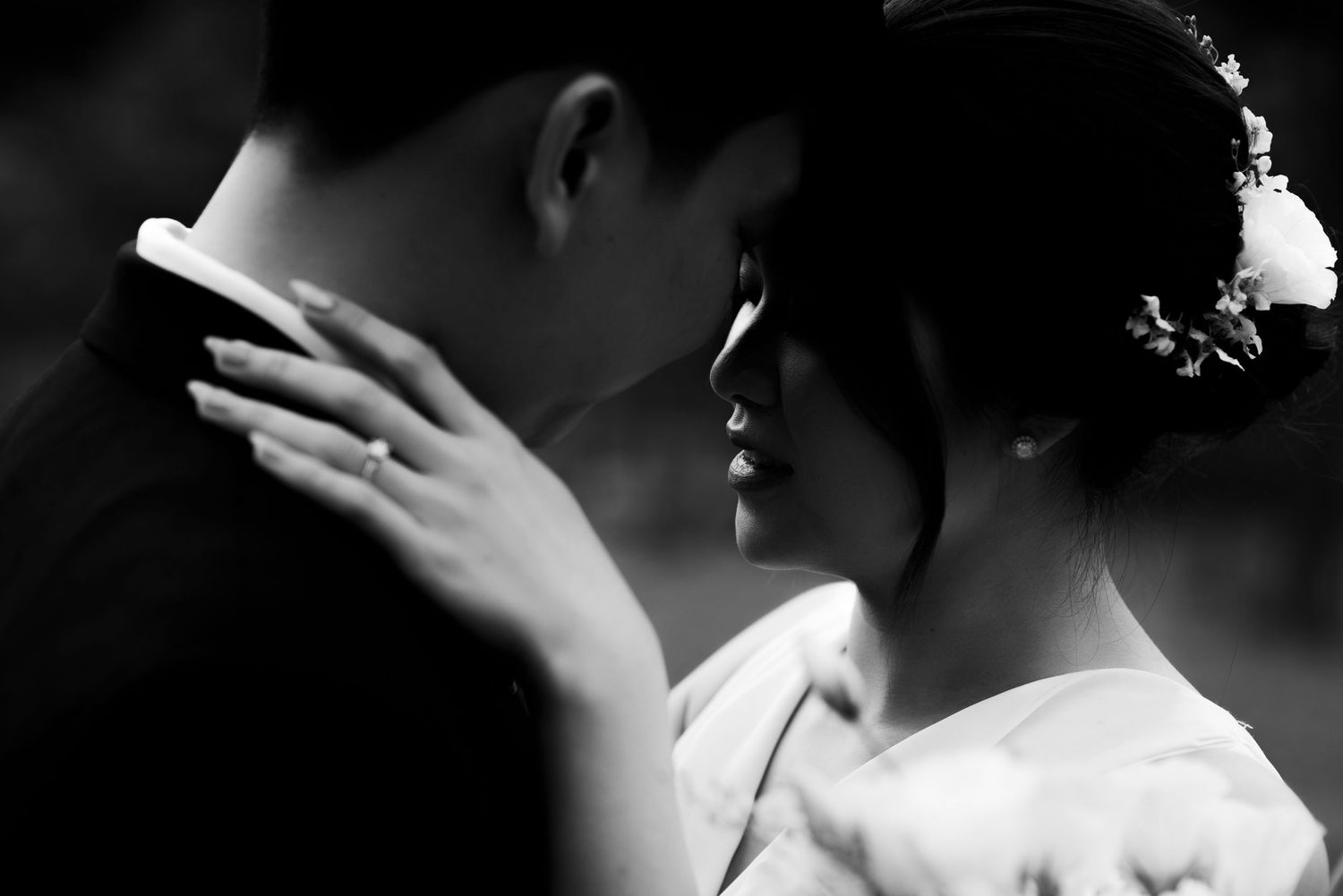 An intimate black and white portrait of a tender wedding moment.