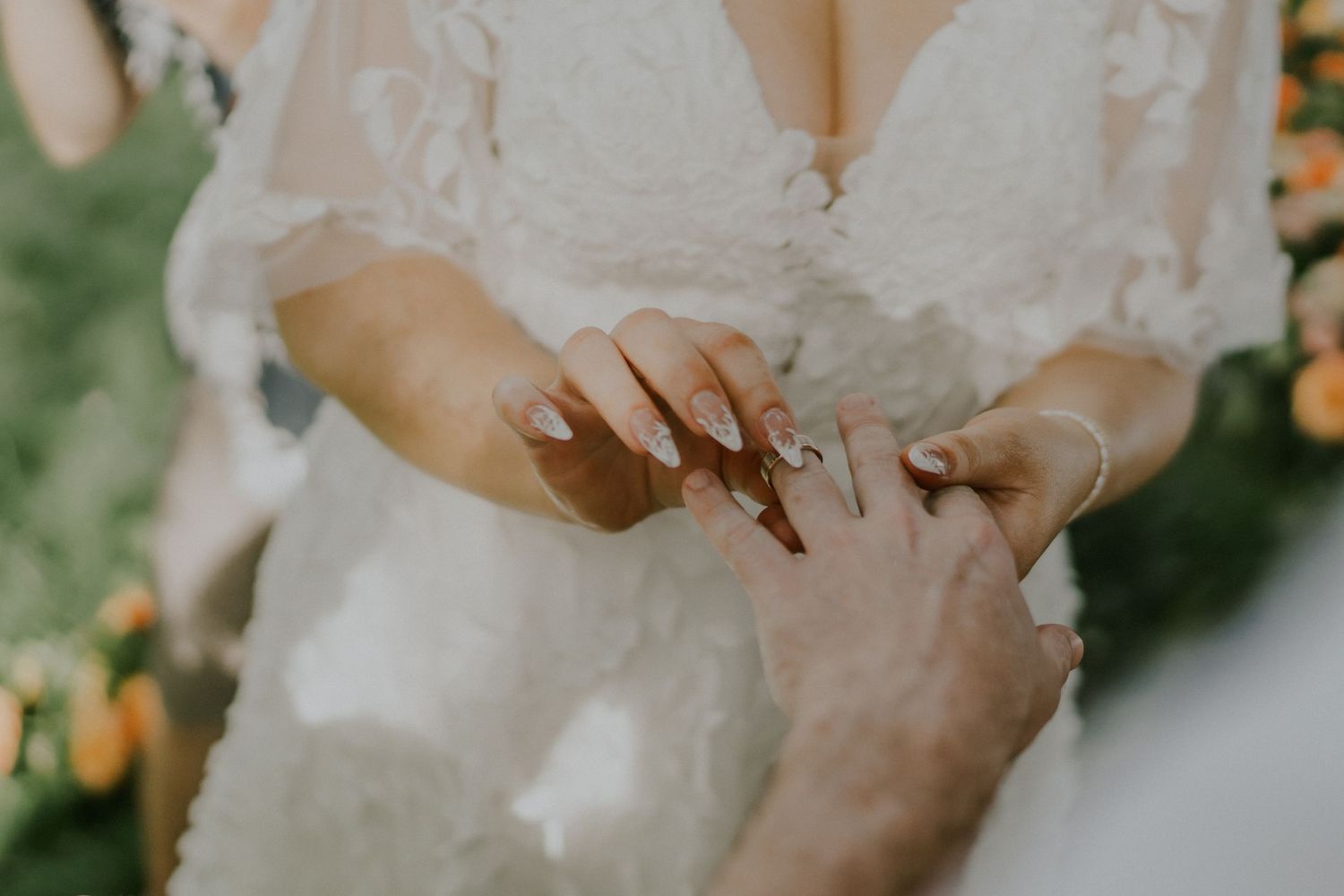 Close-up of hands exchanging rings during wedding ceremony.