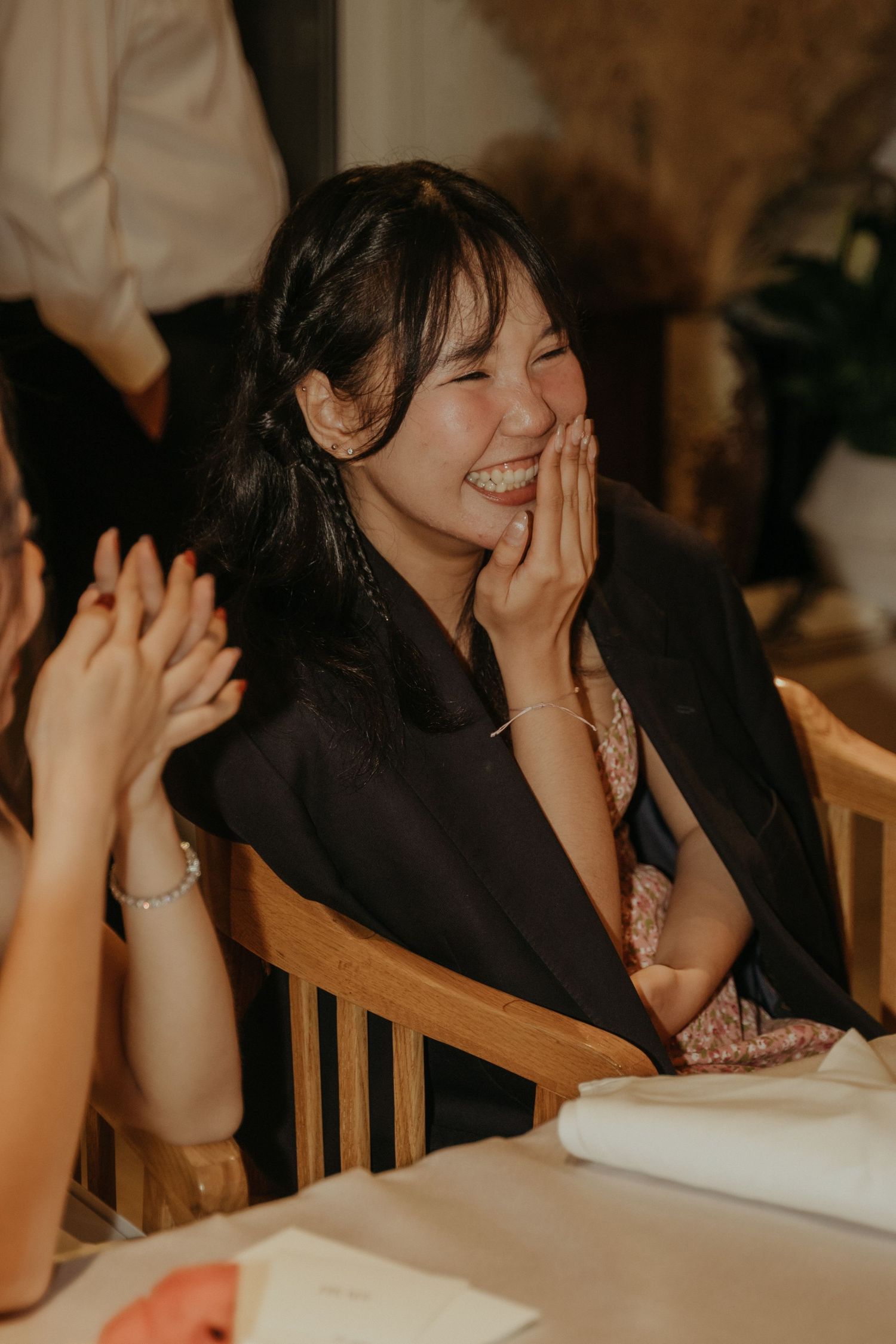 Guest laughs joyfully during wedding reception dinner.