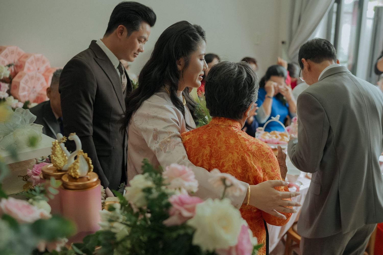 Wedding reception gathering with traditional Vietnamese customs and decorations.