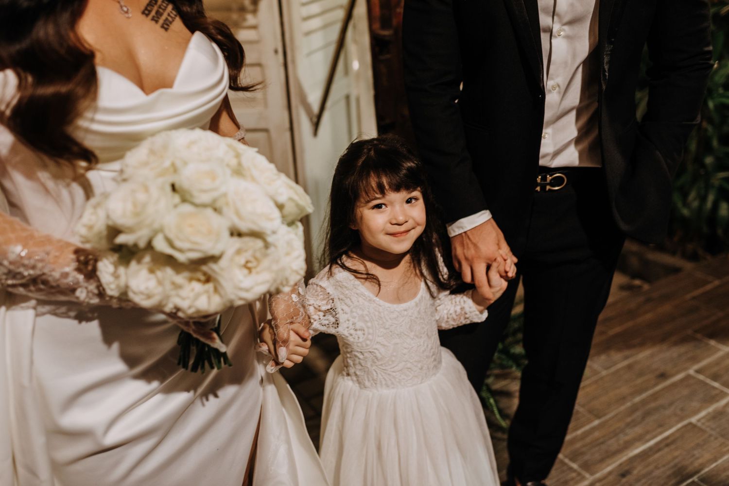 Close-up shot of white wedding bouquet and dress details.