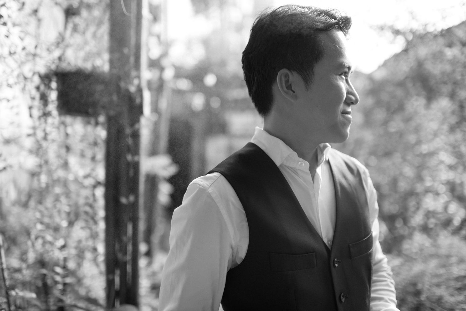 Side profile portrait in black and white of someone wearing a formal vest and white shirt.