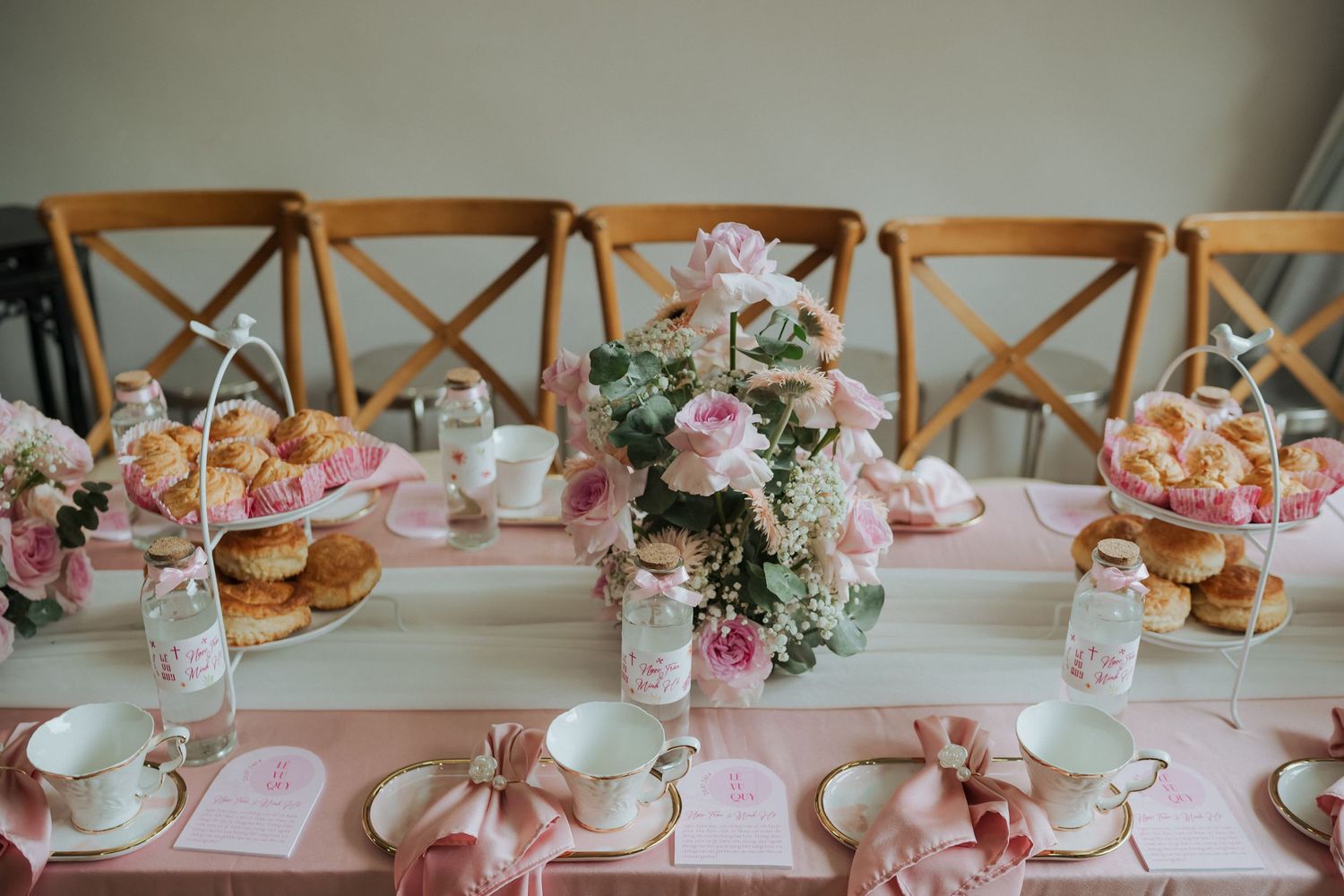 Pink and white table setting with floral centerpieces and delicate tea service.