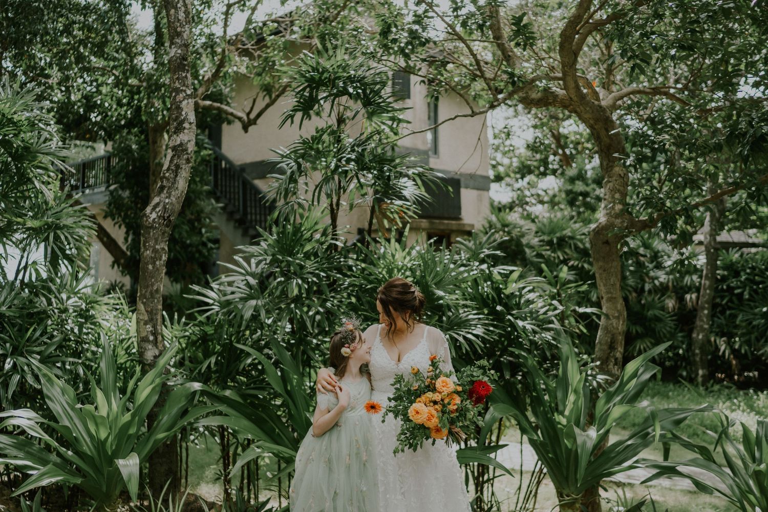 Garden pathway with lush tropical plants and white wedding dress details.
