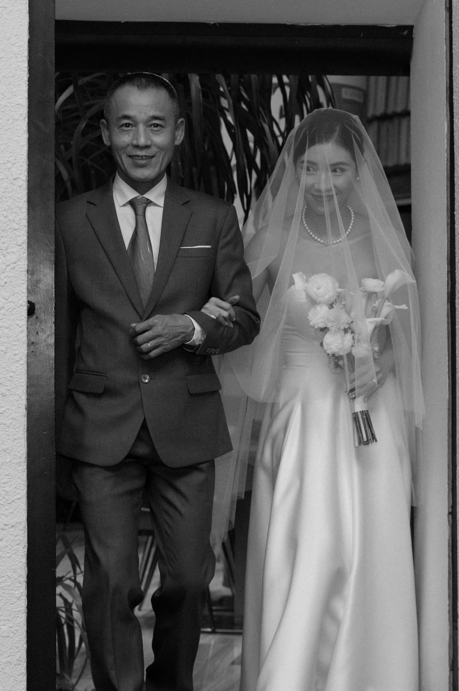 Black and white portrait of a couple in formal wedding attire.