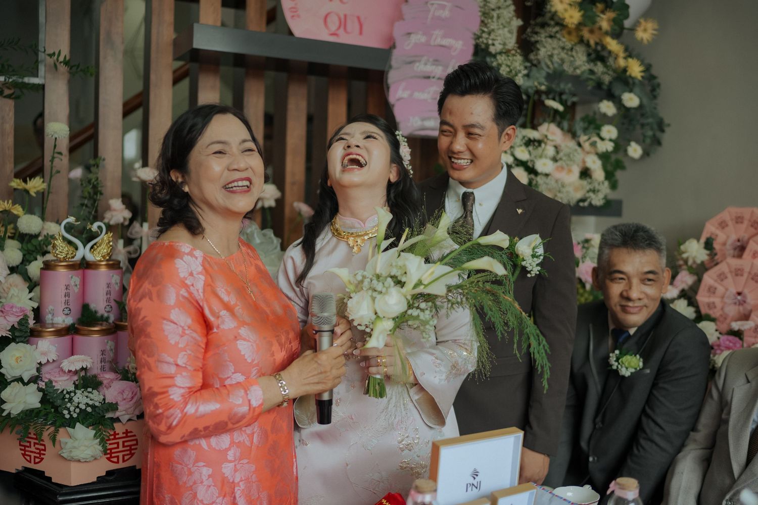 Joyful moment at an elegant wedding celebration featuring laughter and floral decorations.