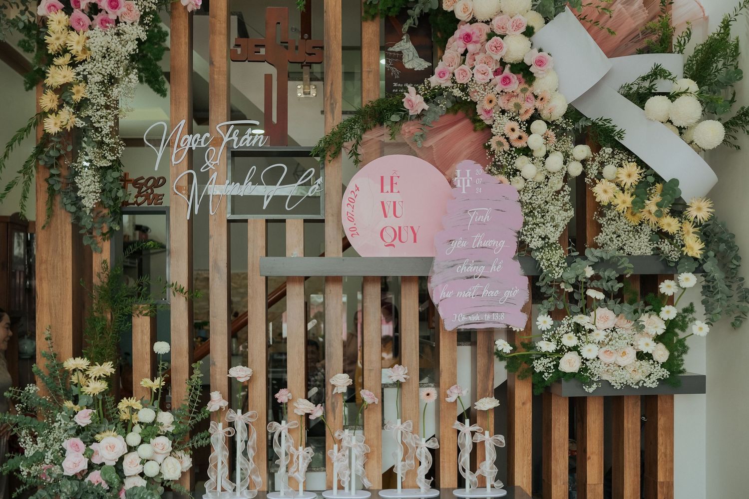 Wooden wall installation with pink paper lanterns and cascading white floral decorations.