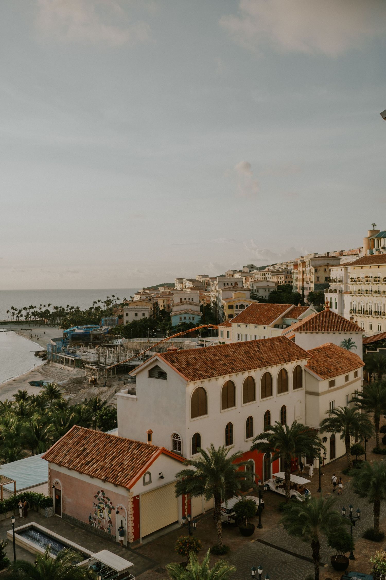 Coastal Mediterranean village with white buildings and terra cotta roofs cascading down to the sea.