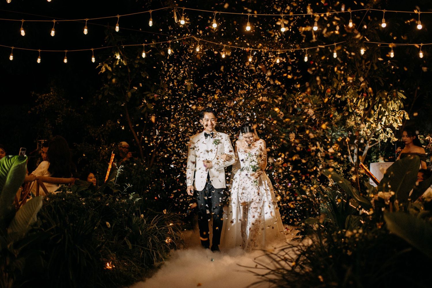 Newlyweds walk through a magical tunnel of sparklers and twinkling lights at their evening reception.