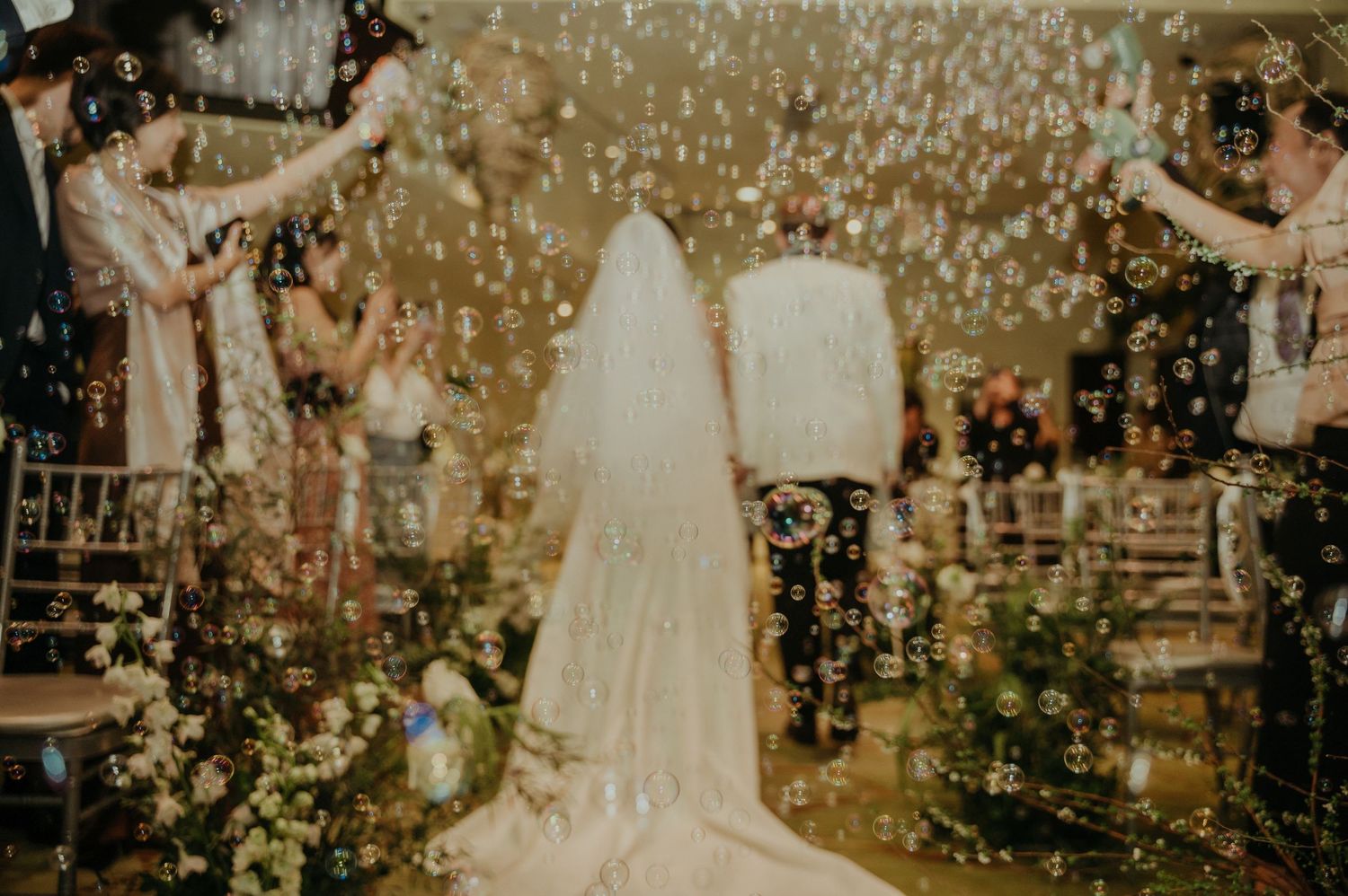 Confetti falls upon a couple during their wedding ceremony in an intimate indoor venue.