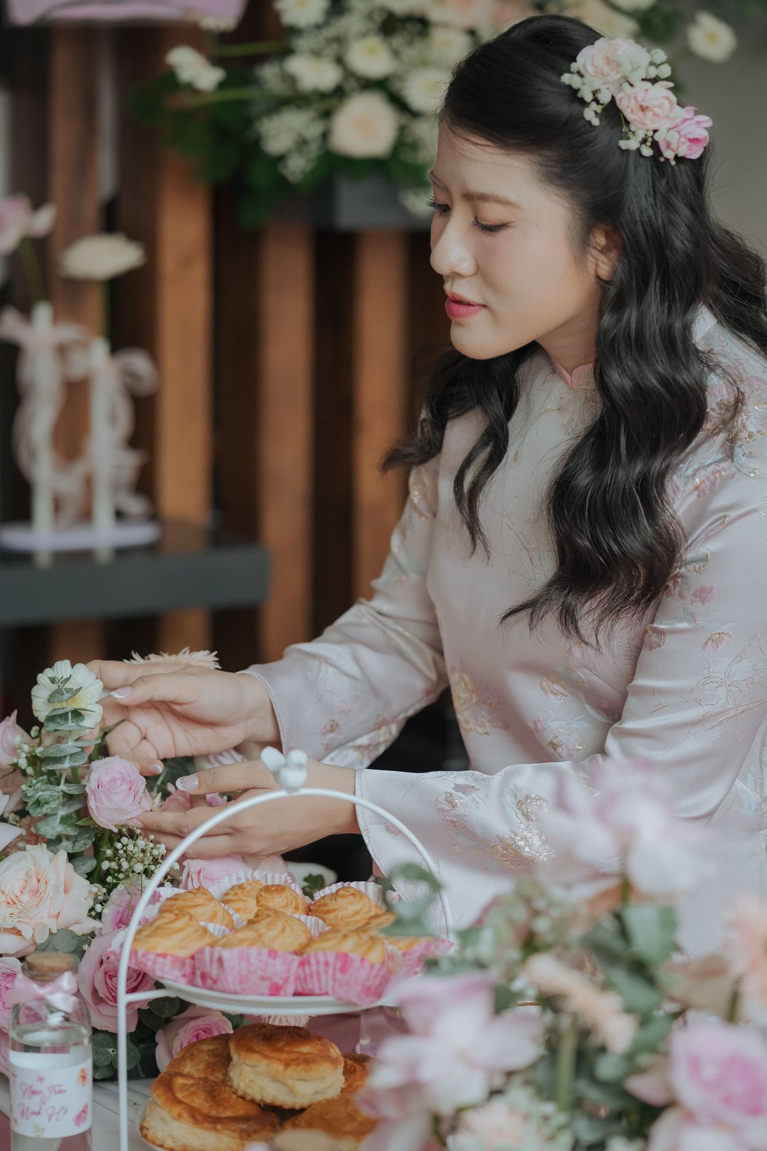 A table is set for a romantic afternoon tea with pink pastries and delicate floral decorations.