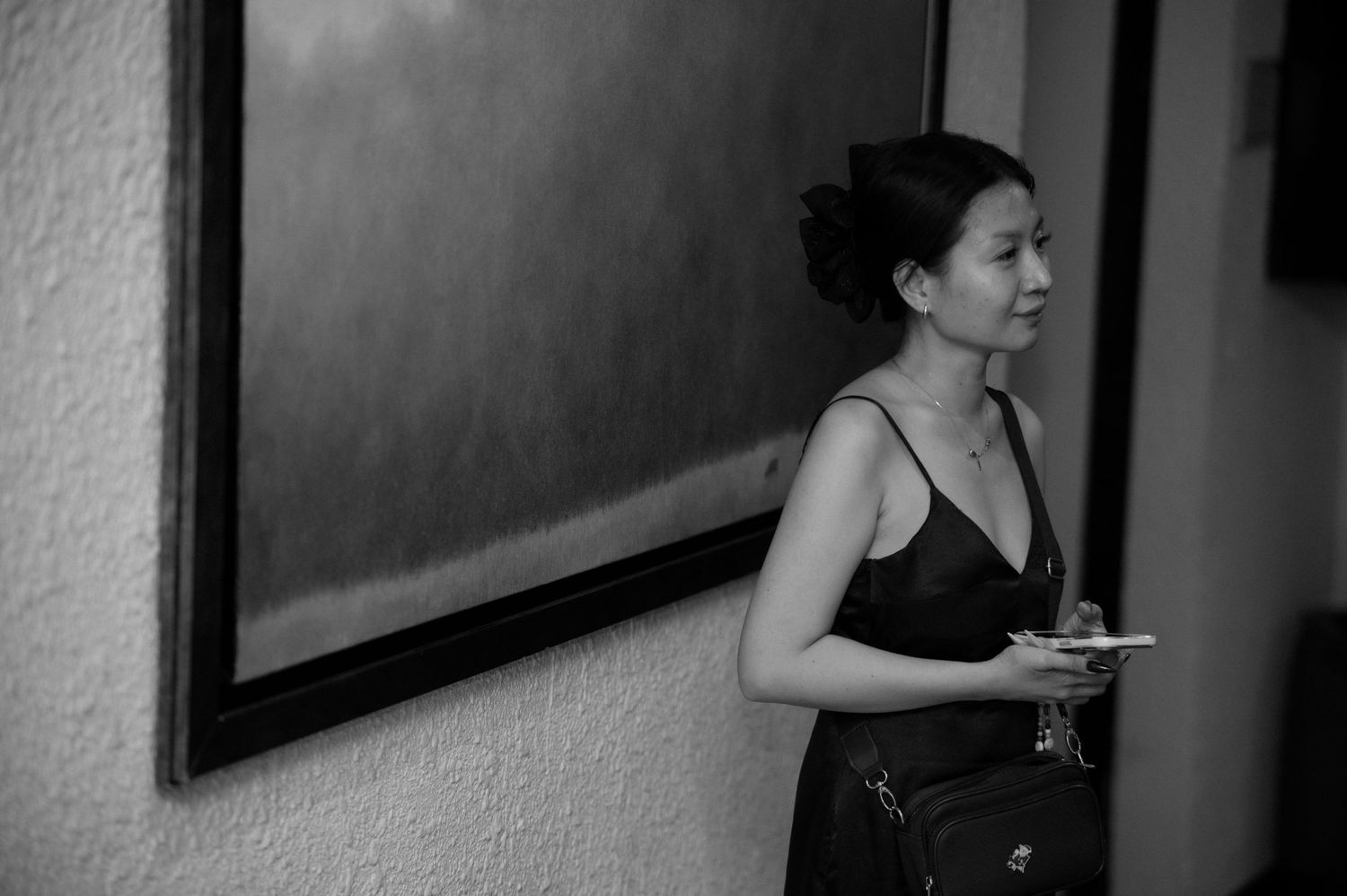 A candid black and white portrait of someone in formal attire holding a plate.