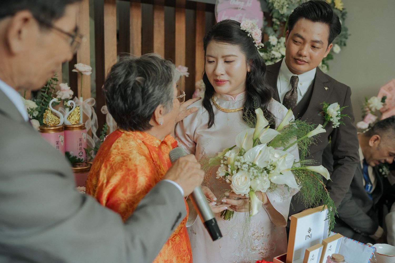 Intimate moment during Vietnamese tea ceremony with traditional dress and decor.