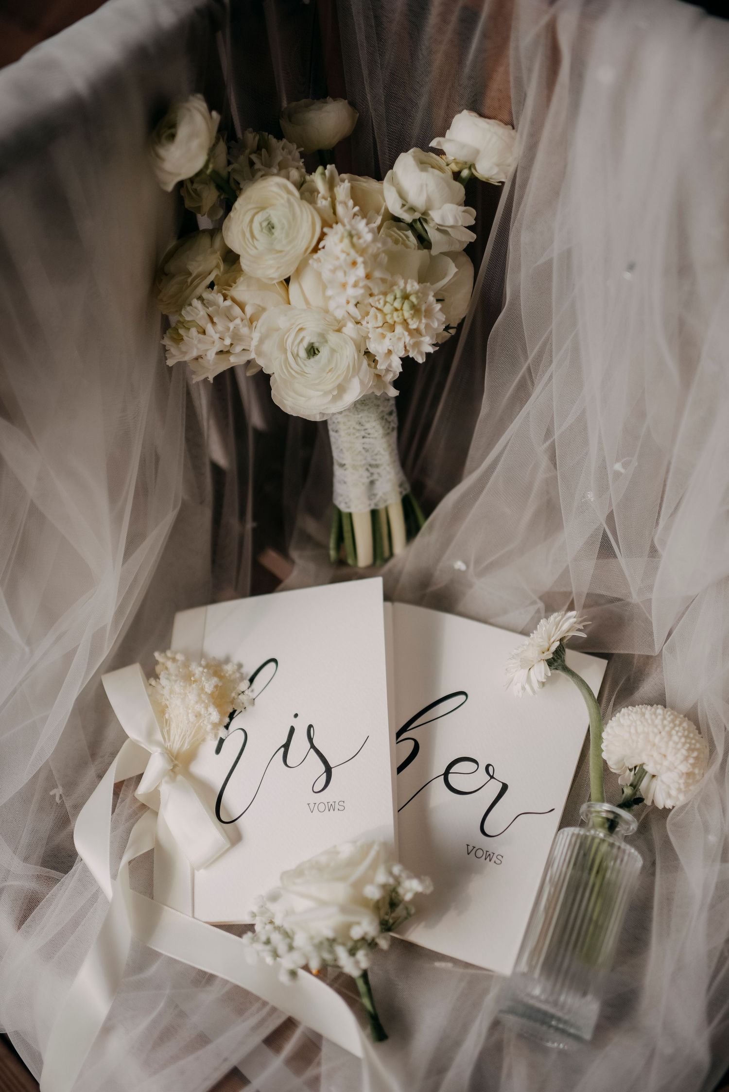 White wedding bouquet with roses and calligraphy 'his her' cards styled with delicate tulle.