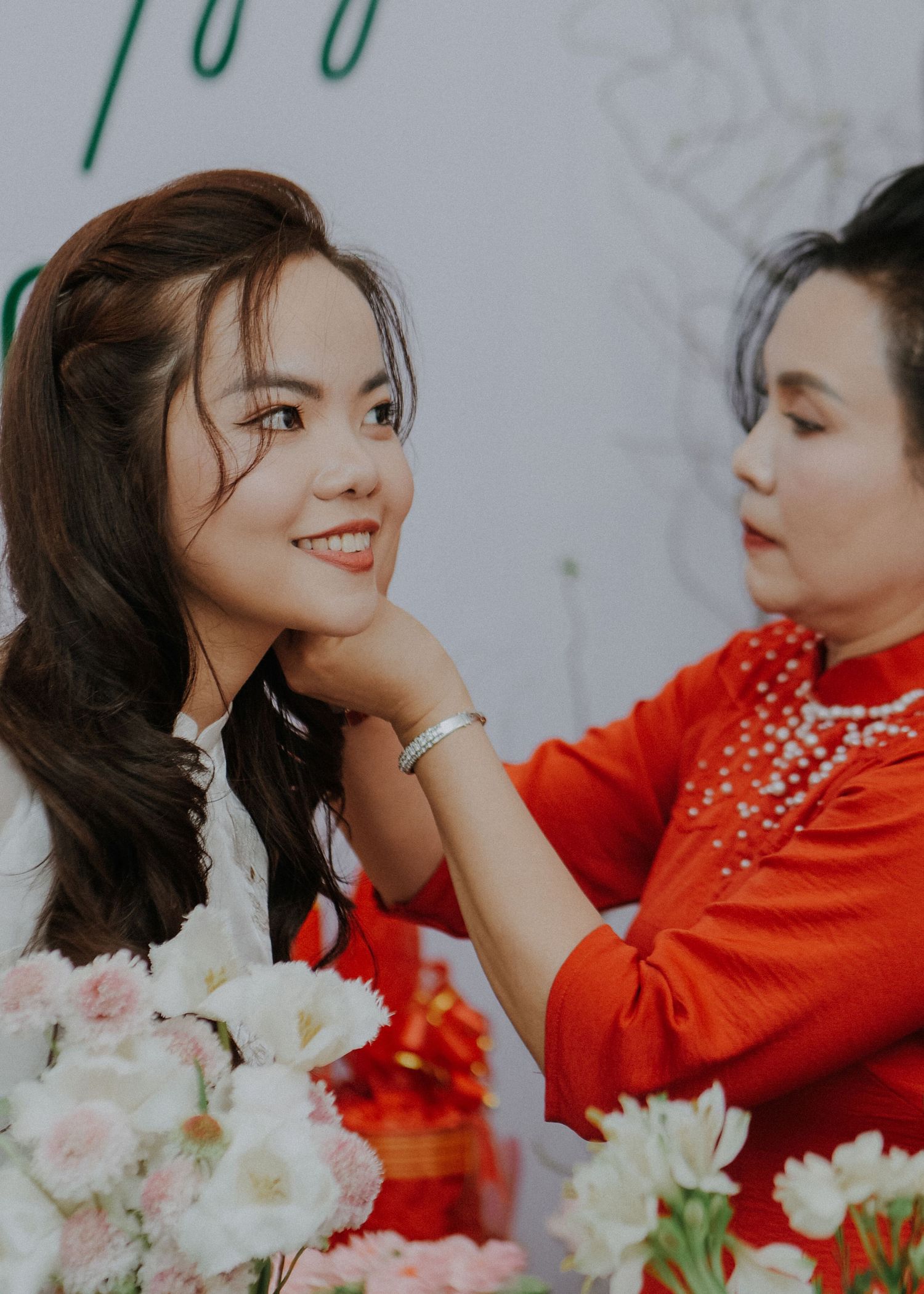 Getting ready moment with traditional Vietnamese wedding attire and pink floral arrangements.