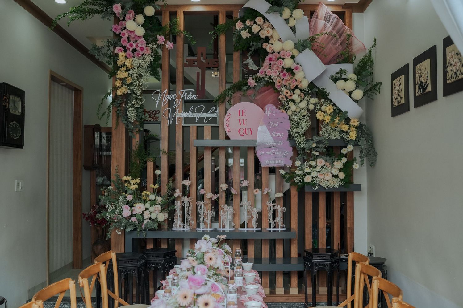 Interior space with wooden slats decorated with pink paper lanterns and white floral garlands.
