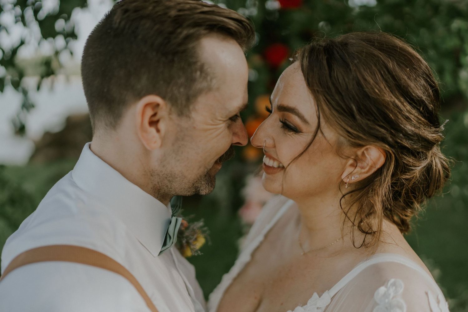 Intimate moment between newlyweds sharing a tender embrace during outdoor garden wedding.