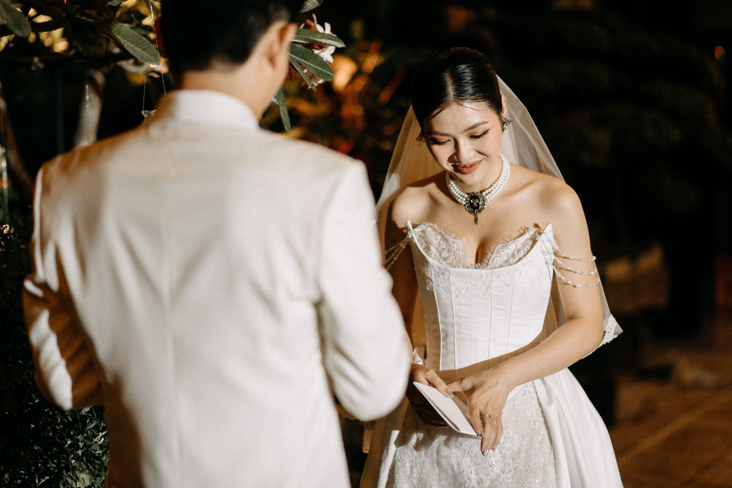 Intimate moment during wedding ceremony with couple in elegant white attire.
