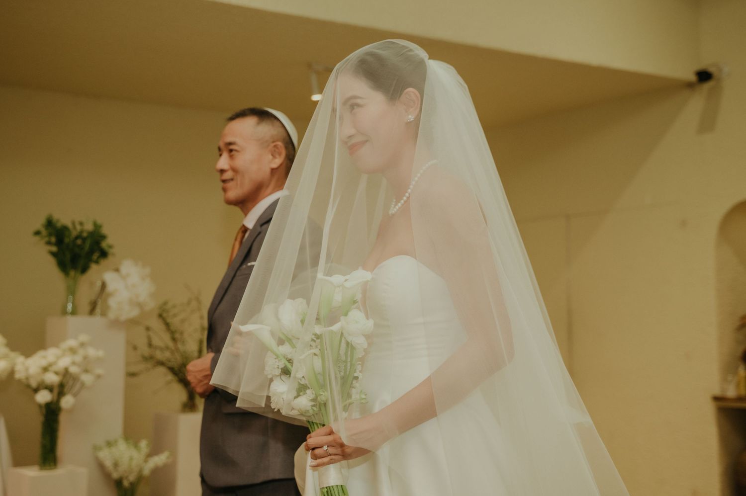 A tender moment during a wedding processional with the couple in traditional attire.