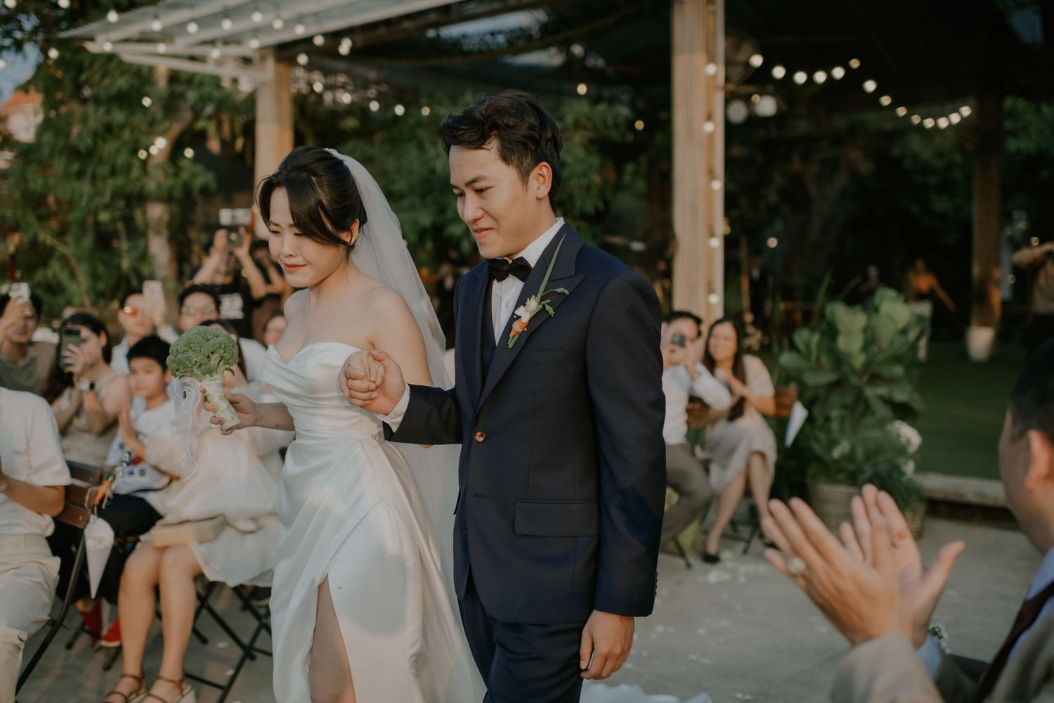 A wedding celebration in a garden venue with string lights and gathered guests.