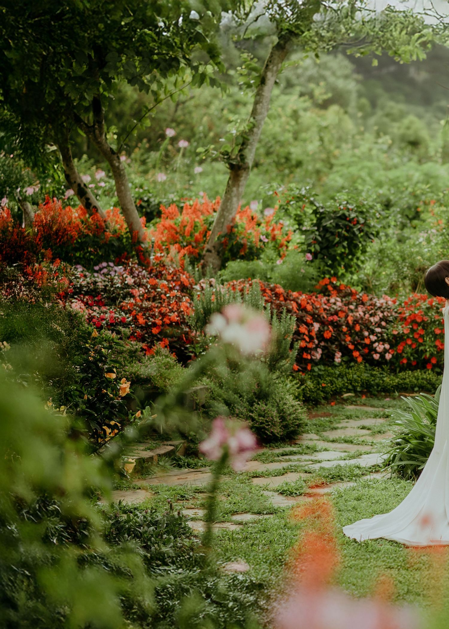 A winding garden path surrounded by vibrant orange flowers and lush greenery creates a peaceful outdoor sanctuary.