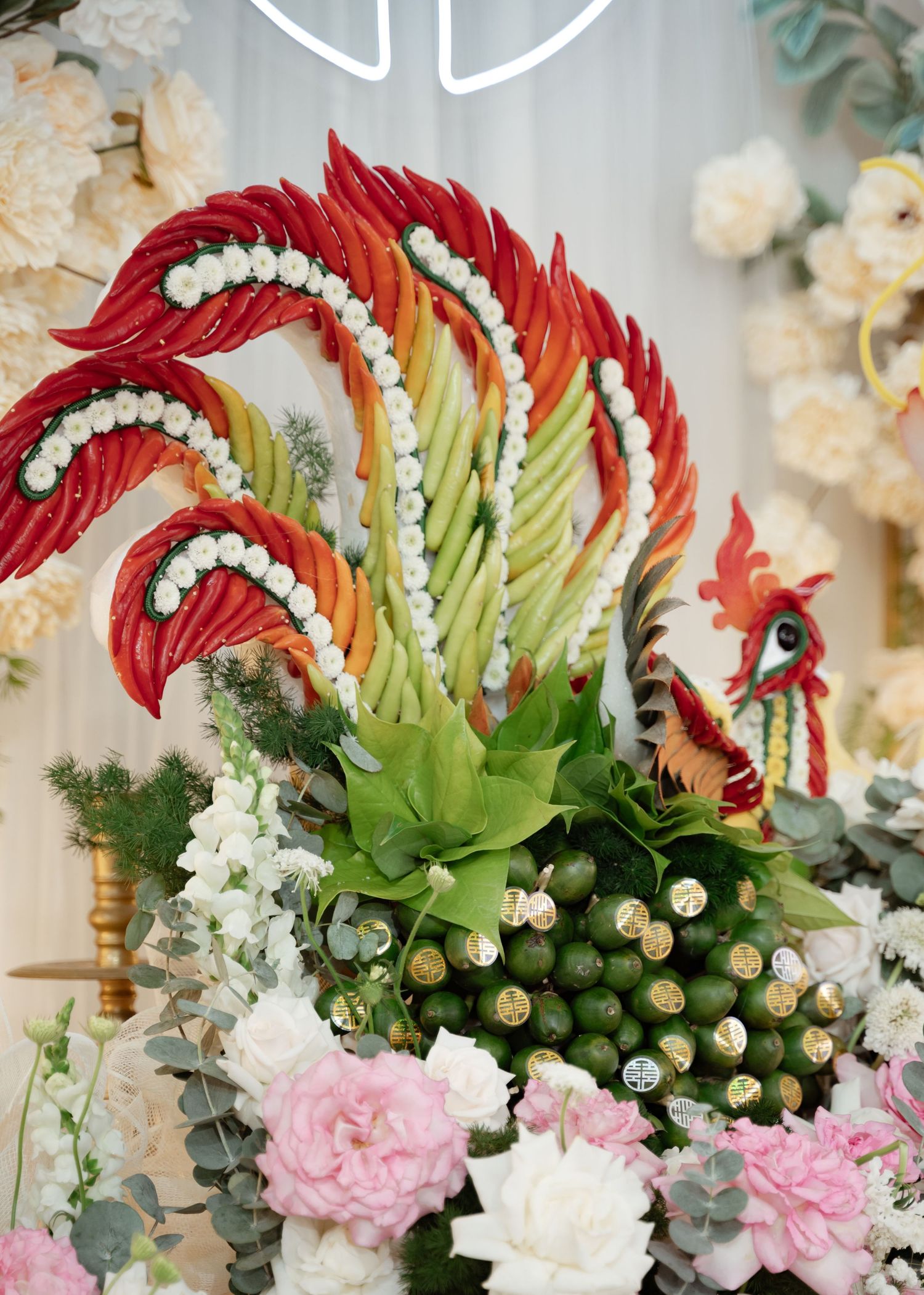 A vibrant floral arrangement featuring red chili peppers styled as a rooster with pink carnations and greenery.