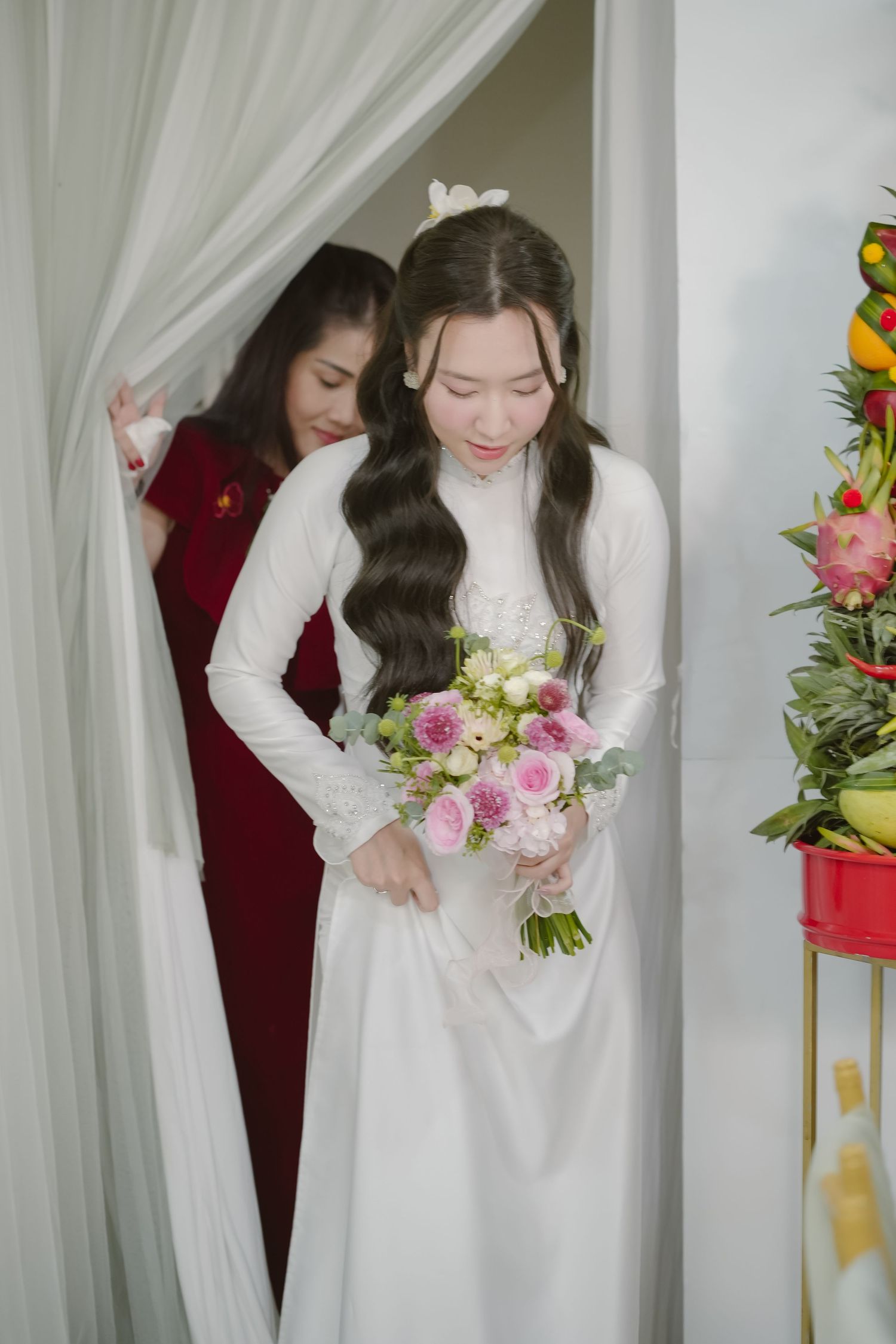 Traditional Vietnamese wedding ceremony moment with white and red attire.