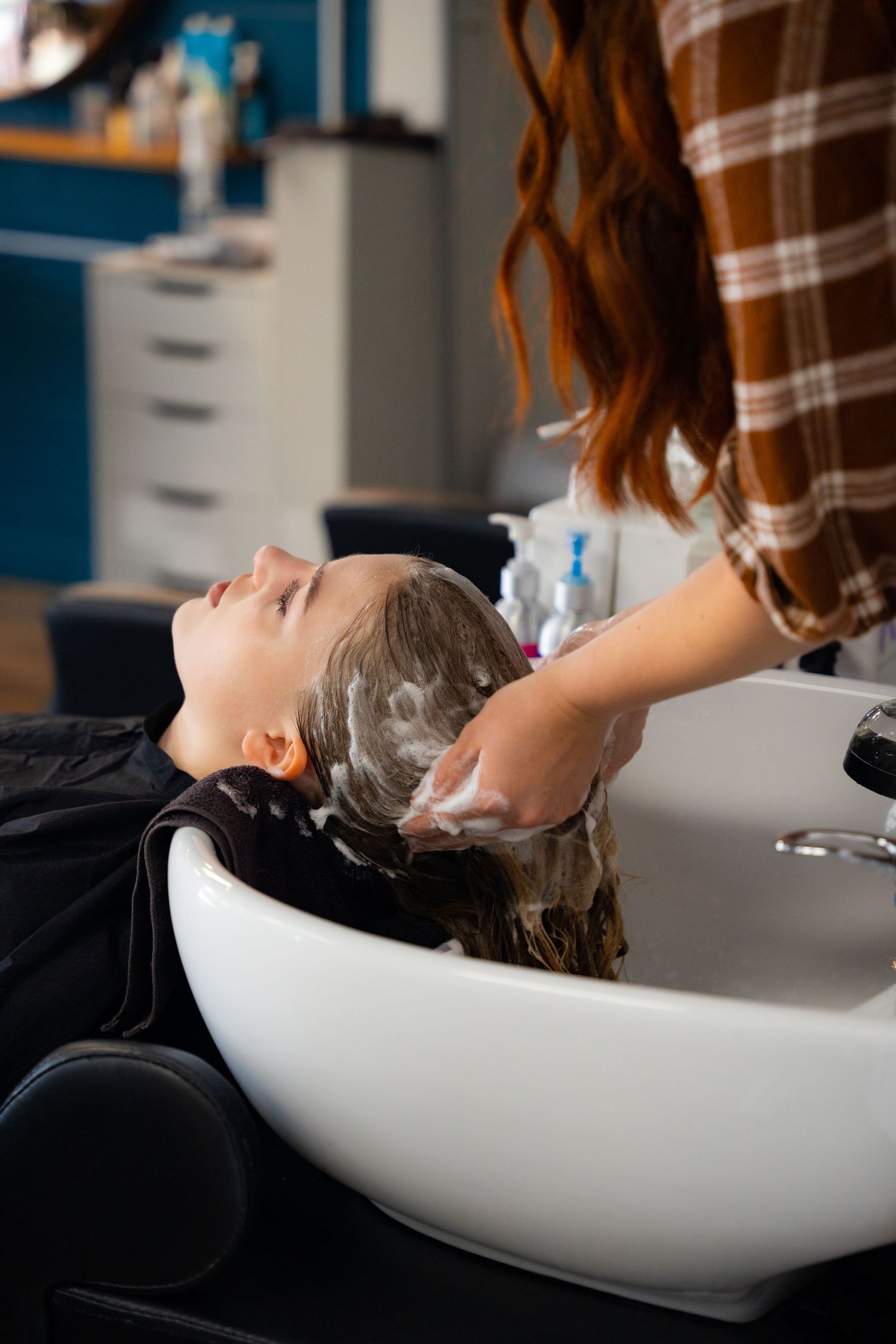 Hair washing service at a salon sink with professional hair care treatment.