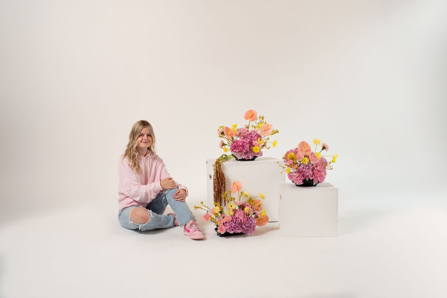 Lifestyle photo shoot with fresh flower arrangements on geometric white display blocks.