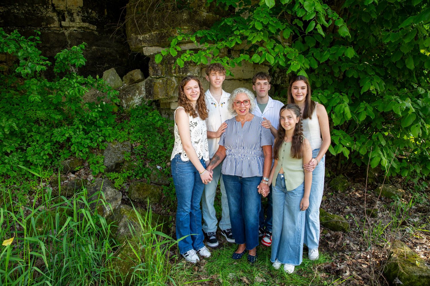 Group photo in a natural outdoor setting with green trees and vegetation.