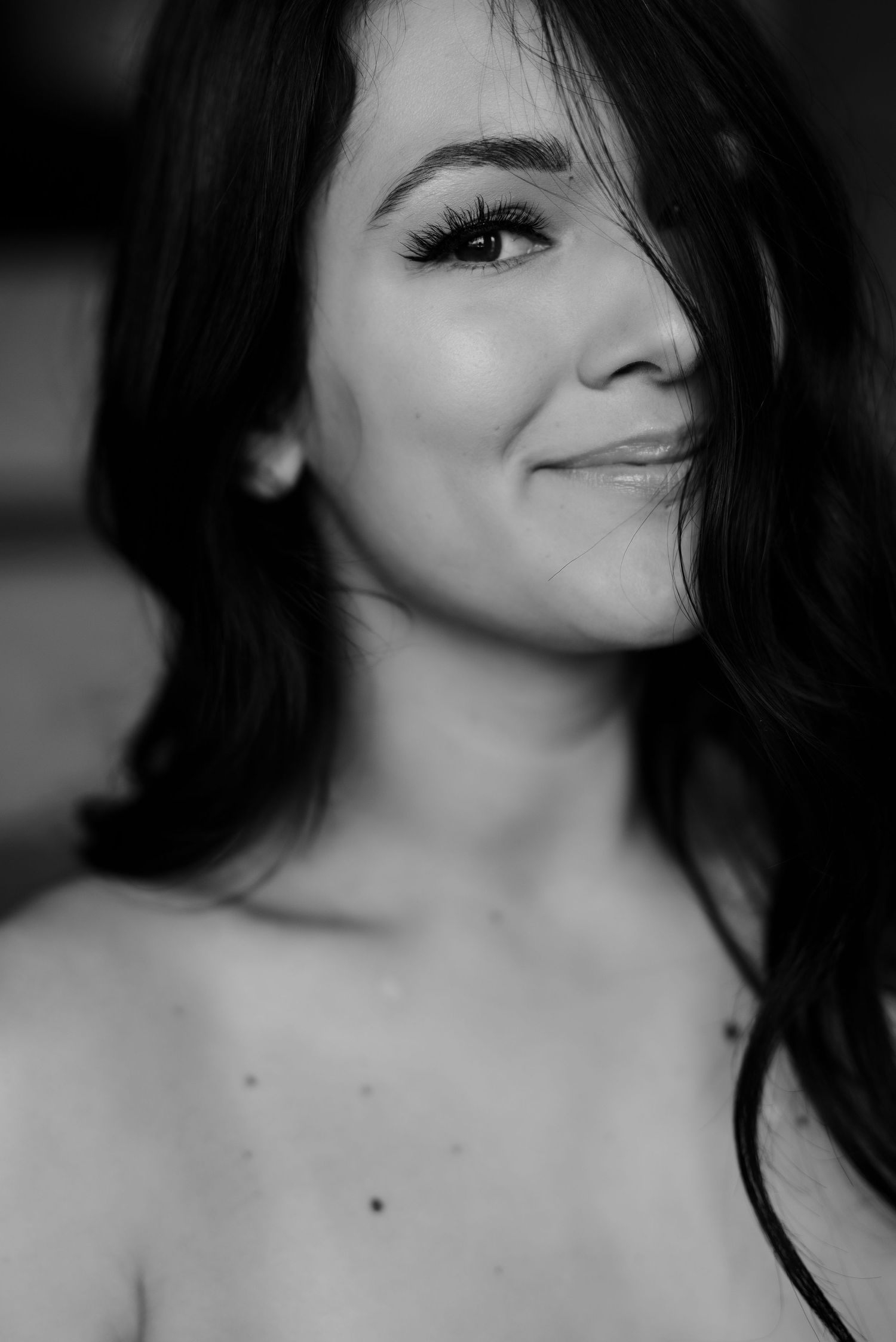 Black and white close-up portrait with soft lighting highlighting natural beauty.