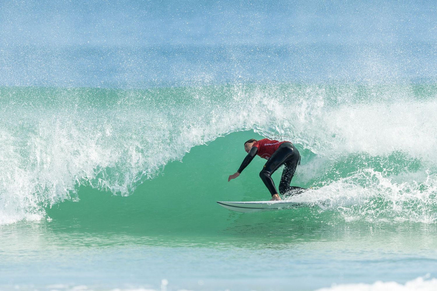 A surfer rides a turquoise wave in sequence of continuous motion shots showing progressive movement across the water.