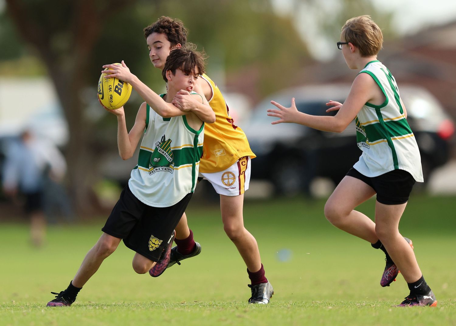 Athletes crouching and preparing for a game on grass field in sports uniforms.