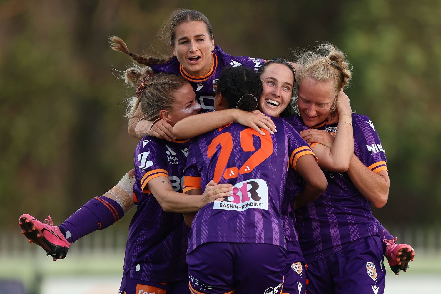 Group of players in purple jerseys celebrating together during a match.
