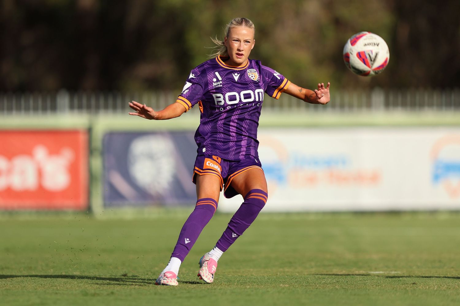 Soccer player in purple uniform controlling ball during match.