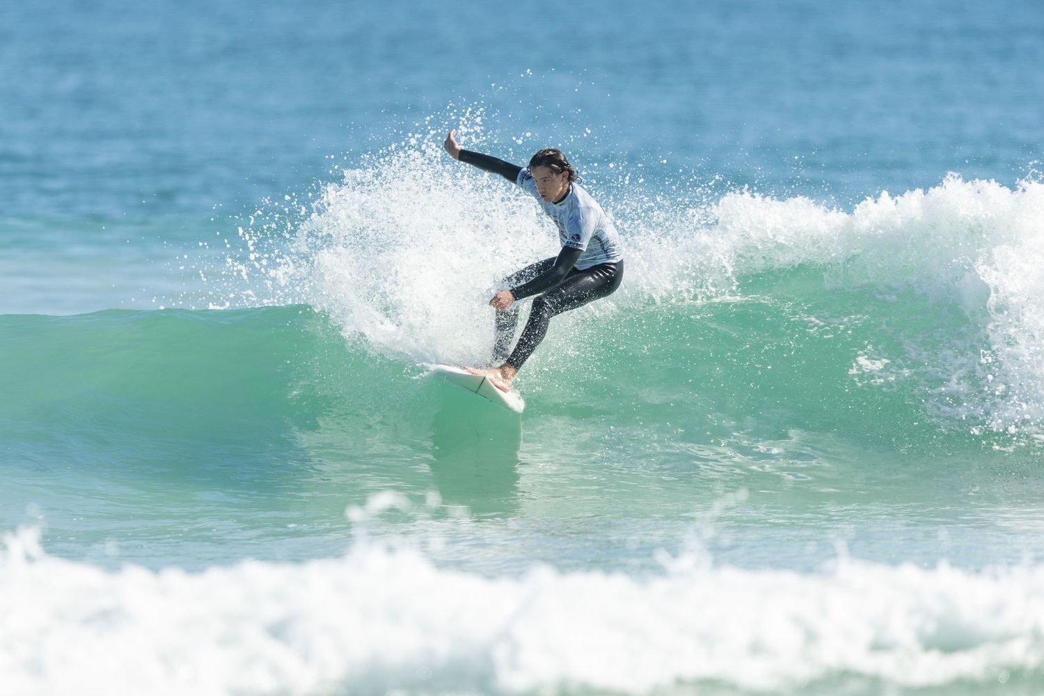 A sequence showing a surfer executing a dynamic aerial maneuver off the crest of an ocean wave.