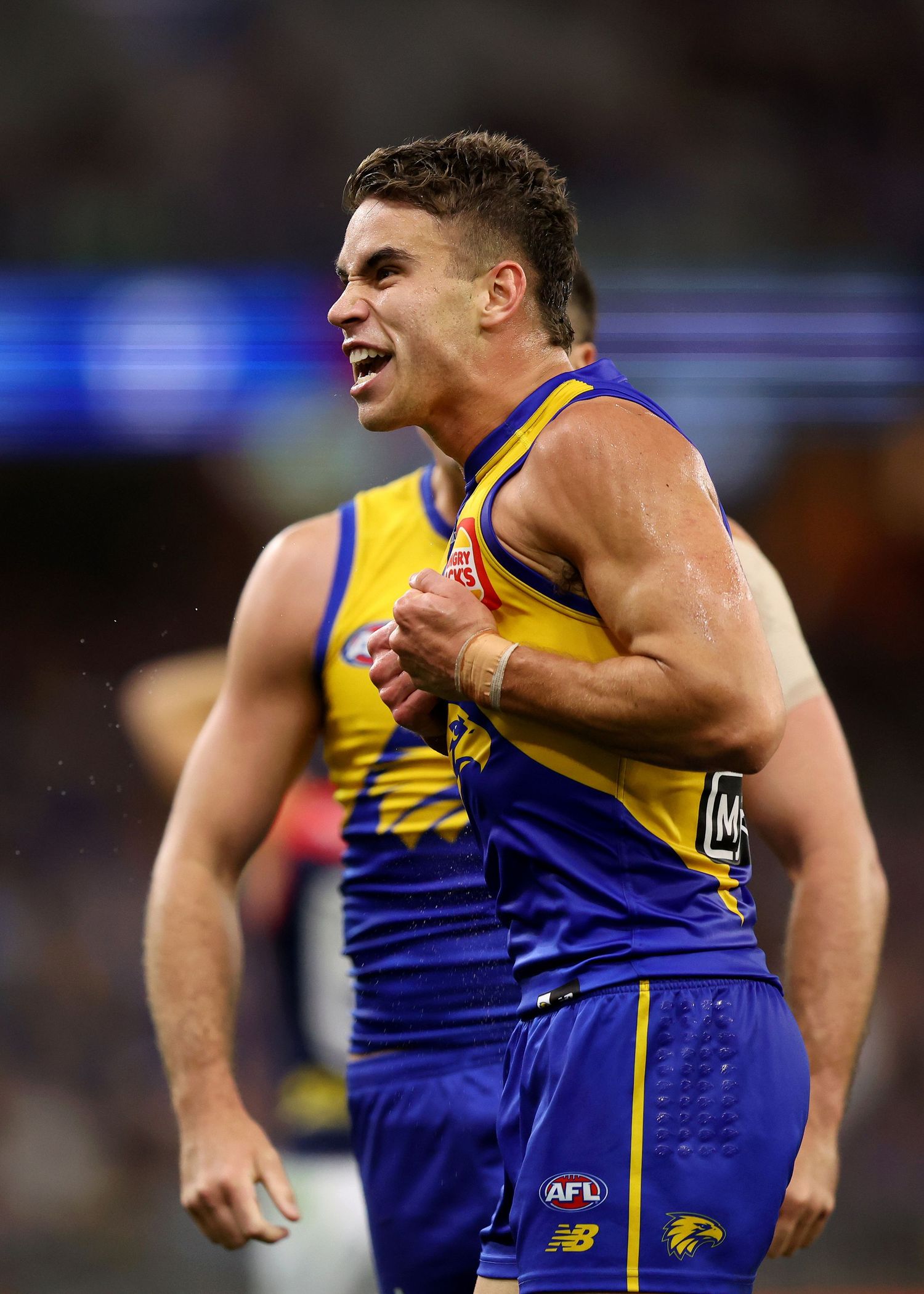 West Coast Eagles player celebrates during AFL match at stadium.