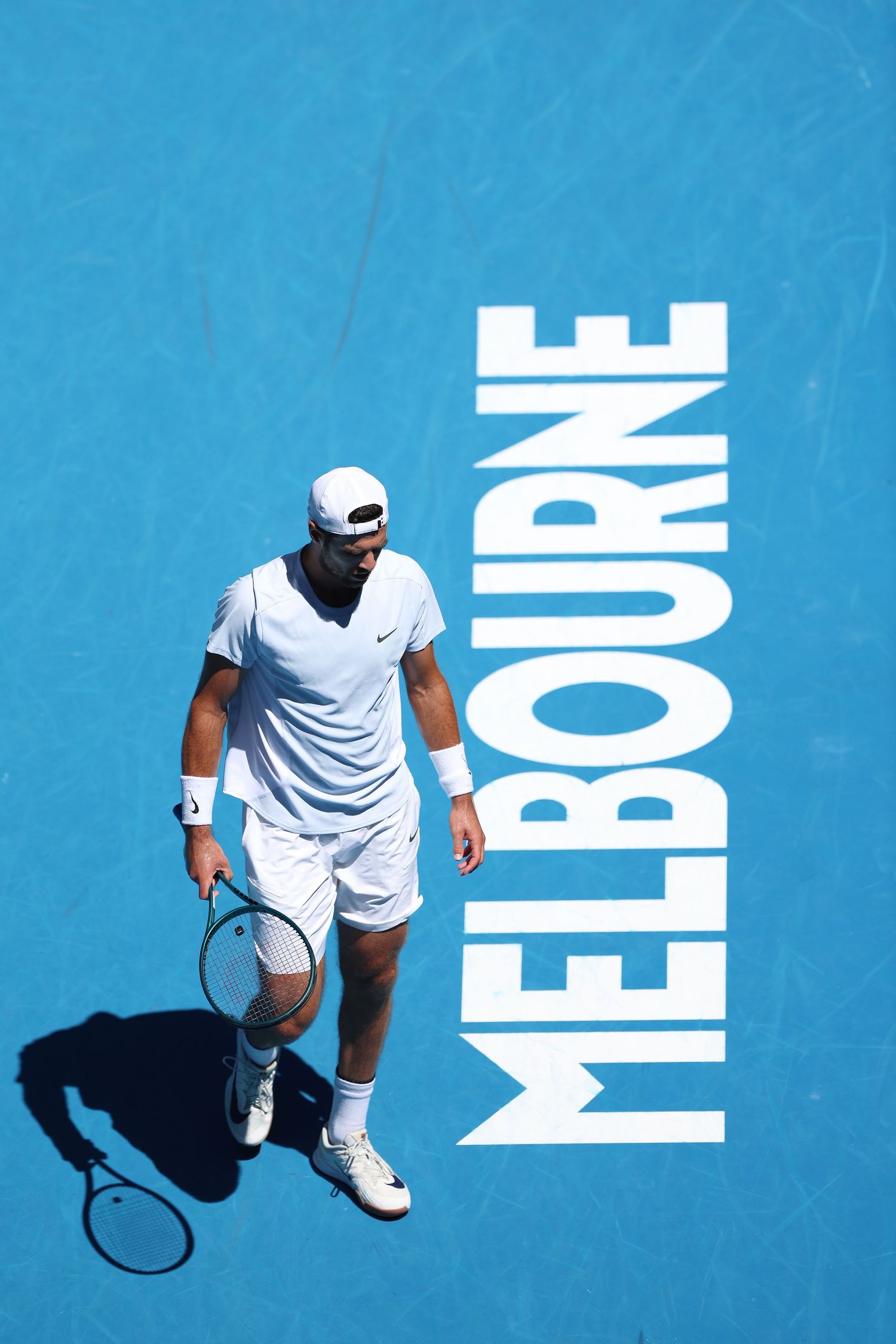 Tennis player in white outfit on Melbourne blue court with large text overlay.